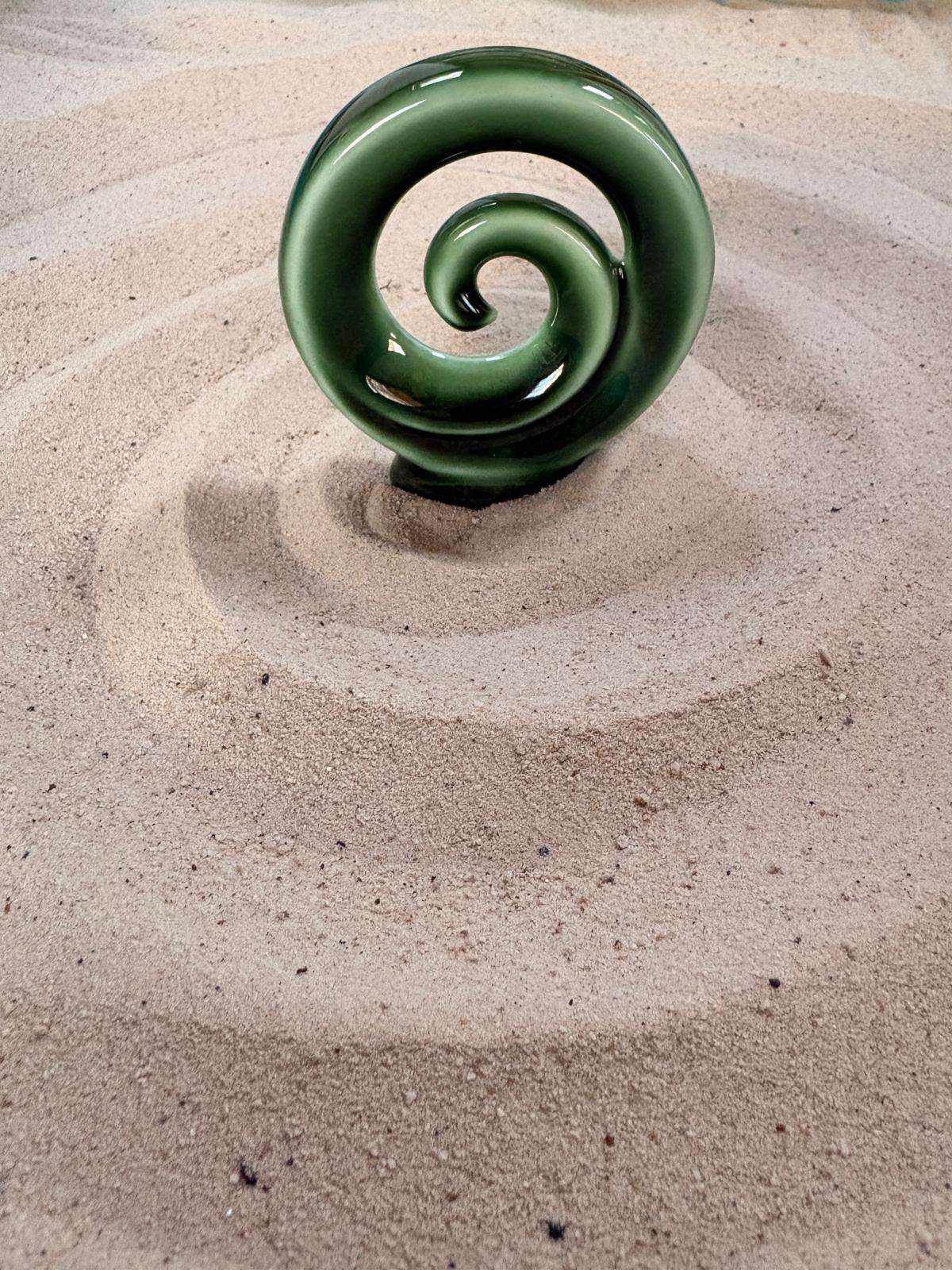 A spiral shape traced in raked sand in a therapy sandtray